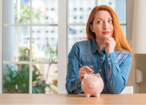 Woman putting a coin in a pink money savvy pig